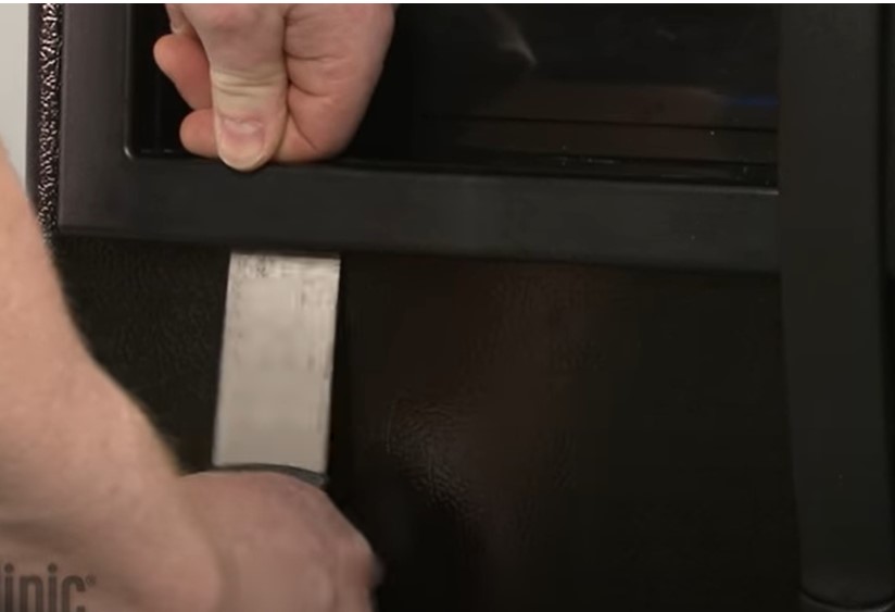 Insert a putty knife to uncover the ice dispenser cover